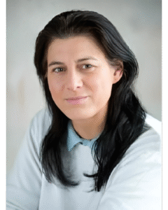 Porträt von Mag. Sabine Keller, einer Frau mit langen, dunklen Haaren und einem freundlichen Lächeln