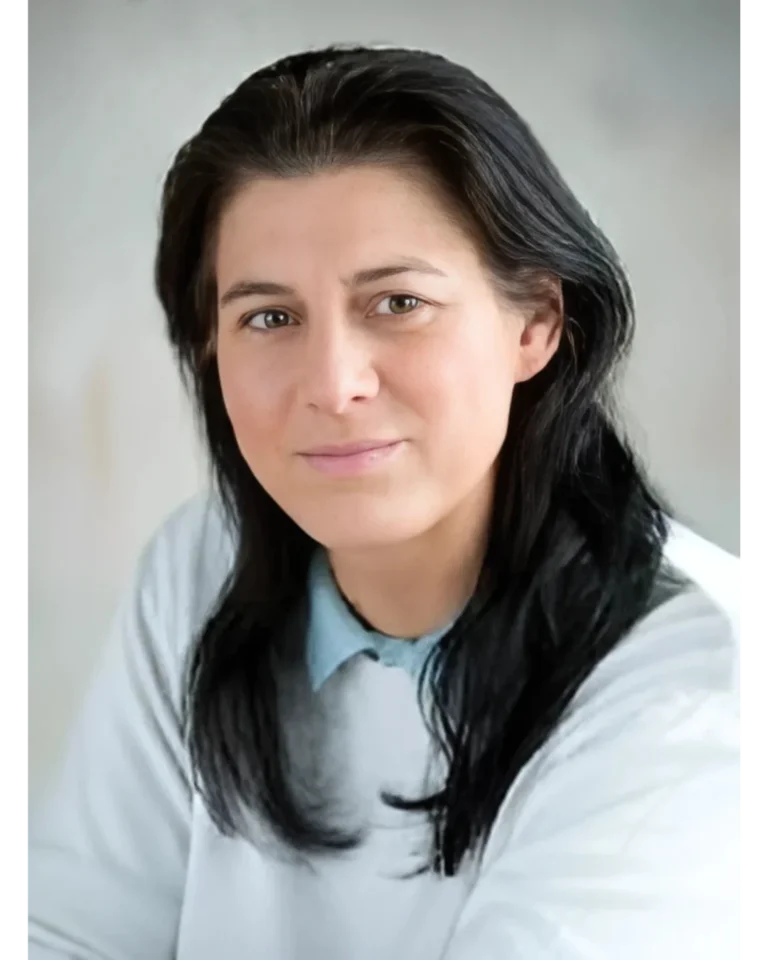 Porträt von Mag. Sabine Keller, einer Frau mit langen, dunklen Haaren und einem freundlichen Lächeln